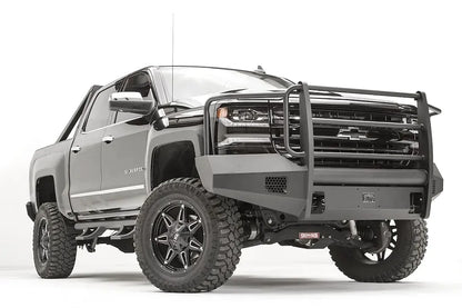Fab Fours Elite front bumper with grille guard on a lifted gray Chevrolet Silverado 1500, low front passenger-side view, with honeycomb vents and shackle mounts