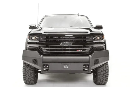 Fab Fours Elite front bumper with pre-runner guard on a black 2016–2018 Chevrolet Silverado 1500, front view showing the low tubular guard, honeycomb side vents, shackle mounts and Elite badge