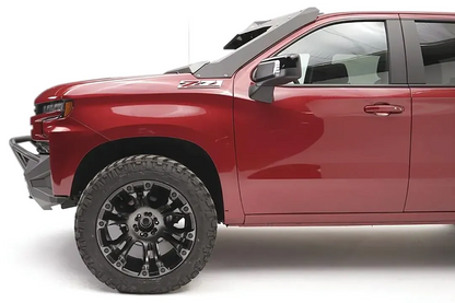 Fab Fours Vengeance front bumper with pre-runner guard on a red Chevrolet Silverado 1500, driver-side profile view, showing the bumper end cap, pre-runner tube, and wheel well clearance