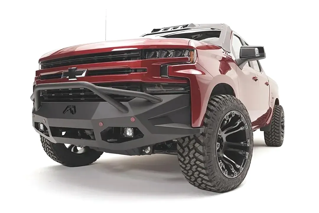 Fab Fours Vengeance front bumper with pre-runner guard on a red Chevrolet Silverado 1500, front driver-side three-quarter view, showing the pre-runner hoop, angular bumper wings, and lower light pods