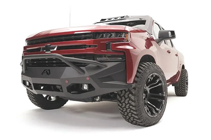 Fab Fours Vengeance front bumper with pre-runner guard on a red Chevrolet Silverado 1500, front driver-side three-quarter view, showing the pre-runner hoop, angular bumper wings, and lower light pods