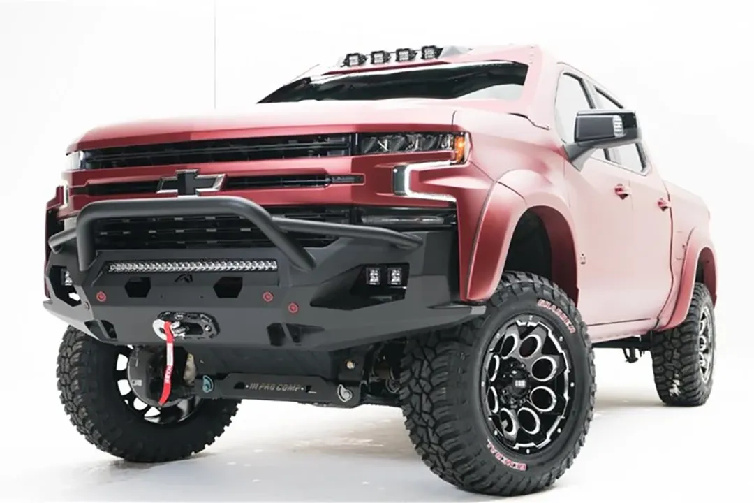 Fab Fours Matrix Front Winch Bumper with pre-runner guard on a lifted red Chevrolet Silverado 1500, front driver-side view, with LED light bar, side cube lights