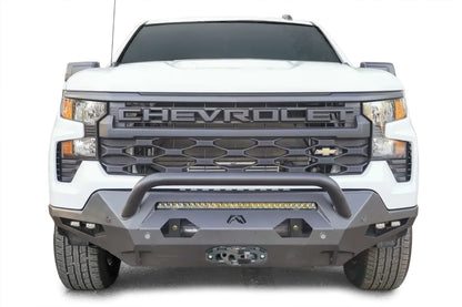 Fab Fours Matrix front bumper with pre-runner guard on a white Chevrolet Silverado 1500, front view, with LED light bar, dual cube lights in each corner, parking sensors, and winch fairlead