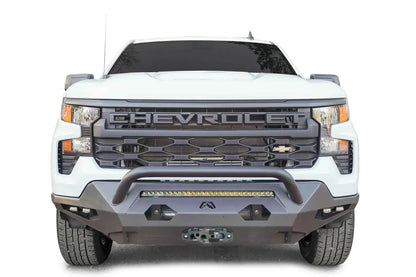 Fab Fours Matrix Front Bumper with pre-runner guard on a white 2022+ Chevrolet Silverado 1500, front view, showing the tubular guard over the LED light bar, side cube lights and winch fairlead