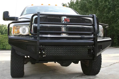 Fab Fours Black Steel front bumper with full guard on a silver Ram 2500, straight-on front view outdoors, showing the full grille guard uprights, diamond-plate face, and headlight hoops