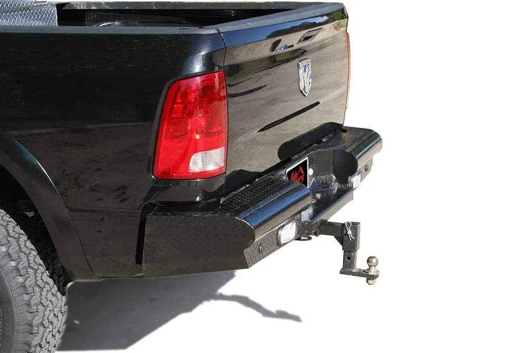 Fab Fours Black Steel Ranch rear bumper with diamond plate on a black Ram 2500, rear three-quarter view