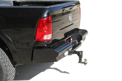 Fab Fours Black Steel Ranch rear bumper with diamond plate on a black Ram 2500, rear three-quarter view