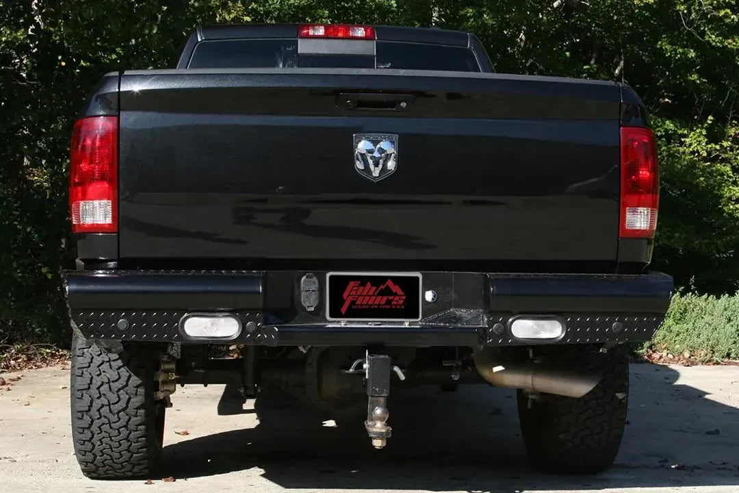 Fab Fours Black Steel Ranch rear bumper on a black Ram 2500, straight rear view, with diamond plate face