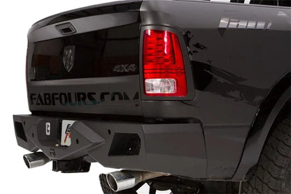 Close-up of Fab Fours Premium rear bumper corner on a black Ram 1500, passenger side, with light opening and hitch receiver
