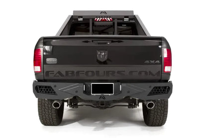 Fab Fours Premium rear bumper on a black Ram 1500 with chase rack, straight rear view, with honeycomb mesh light openings, center license plate mount, and hitch receiver
