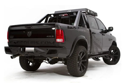 Fab Fours Premium rear bumper on a lifted black Ram 1500 with chase rack and Fab Fours graphics, passenger-side rear three-quarter view