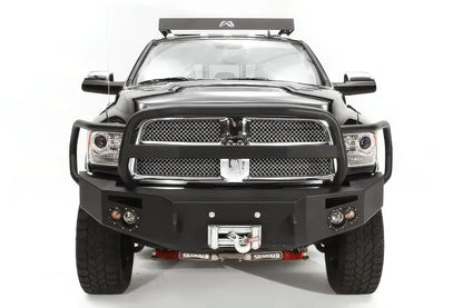 Fab Fours Premium front bumper with full guard on a black Ram 2500, straight-on front view, showing the full grille guard, headlight hoops, and center winch with fairlead