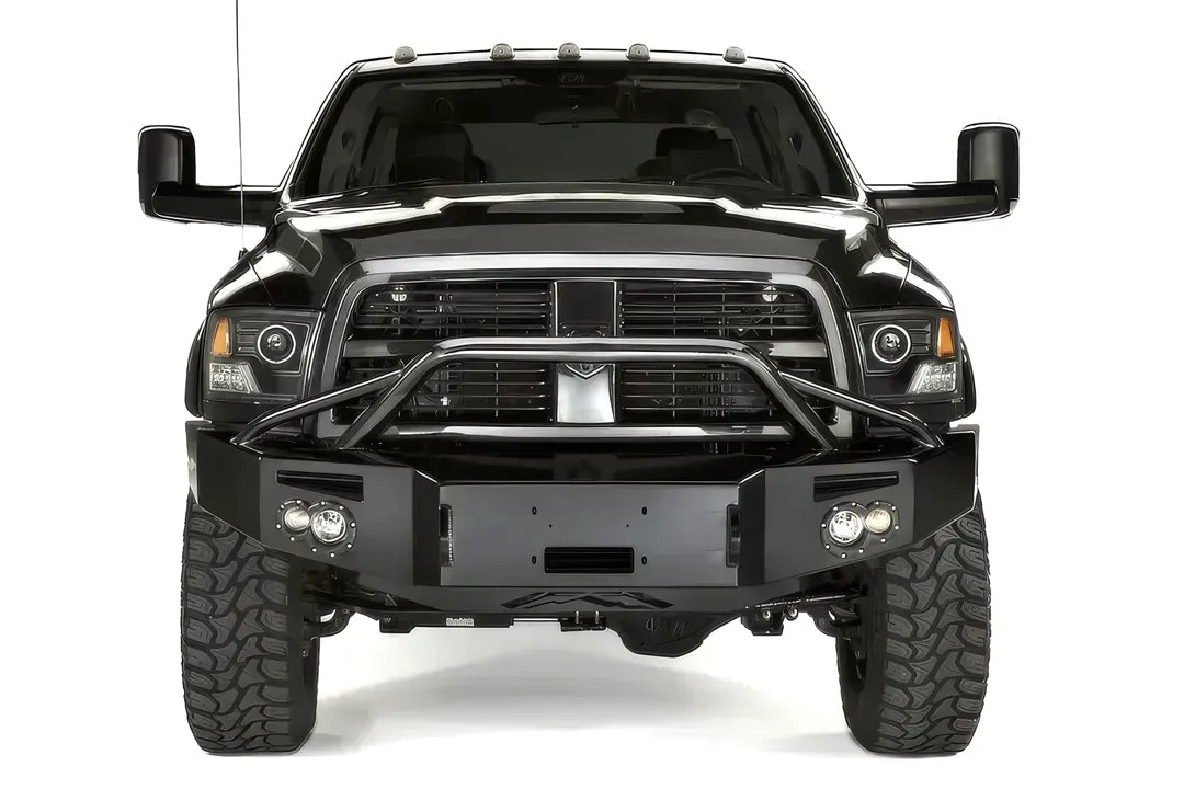 Fab Fours Premium front bumper with pre-runner guard on a black Ram 2500, straight-on front view, showing the tubular pre-runner hoop, winch plate, and round fog lights