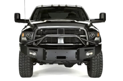 Fab Fours Premium front bumper with pre-runner guard on a black Ram 2500, straight-on front view, showing the tubular pre-runner hoop, winch plate, and round fog lights