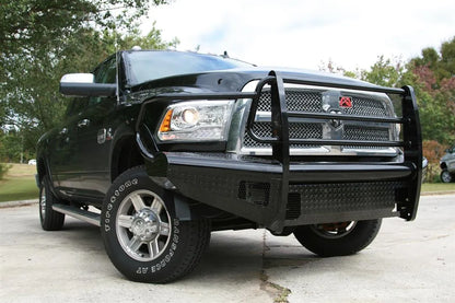 Fab Fours Black Steel front bumper with full guard on a silver Ram 2500, front view outdoors, showing the full grille guard, headlight hoops, and diamond-plate face