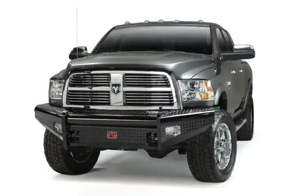 Fab Fours Black Steel front bumper on a gray Ram 2500, front driver-side three-quarter view, showing the diamond-plate face, bumper wings, and red Fab Fours badge