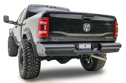 Fab Fours Black Steel Elite rear bumper on a black Ram 2500, rear driver-side three-quarter view, showing the smooth plated face, end cap, and hitch receiver