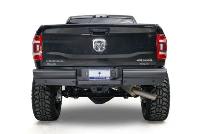 Fab Fours Black Steel Elite rear bumper on a black Ram 2500, straight-on rear view, showing the smooth plated face, center plate recess, and hitch receiver