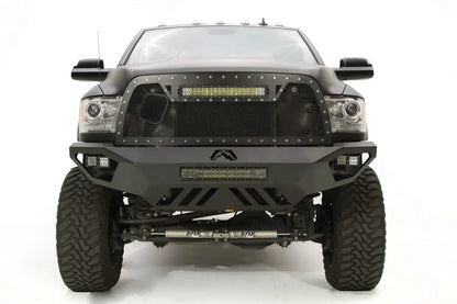 Fab Fours Vengeance front bumper on a gray Ram 2500, straight-on front view, showing the center Fab Fours logo, LED light bar, and slotted skid plate