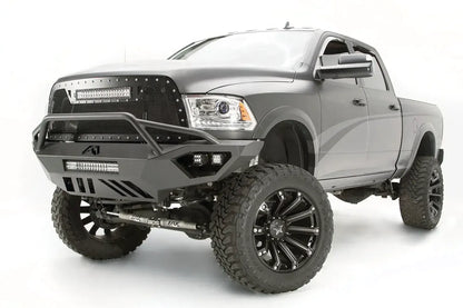 Fab Fours Vengeance front bumper with pre-runner guard on a gray Ram 2500, front driver-side three-quarter view, showing the pre-runner bar, LED light bar, and cube lights
