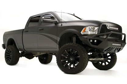 Fab Fours Vengeance front bumper with pre-runner guard on a gray Ram 2500, front passenger-side three-quarter view, showing the pre-runner bar, cube light pods, and angular bumper wing