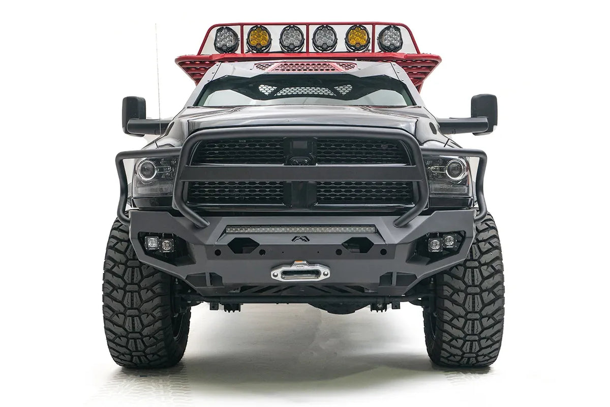 Fab Fours Matrix front bumper with full guard on a gray and black Ram 3500, straight-on front view, showing the tubular grille guard, LED light bar, and center winch fairlead