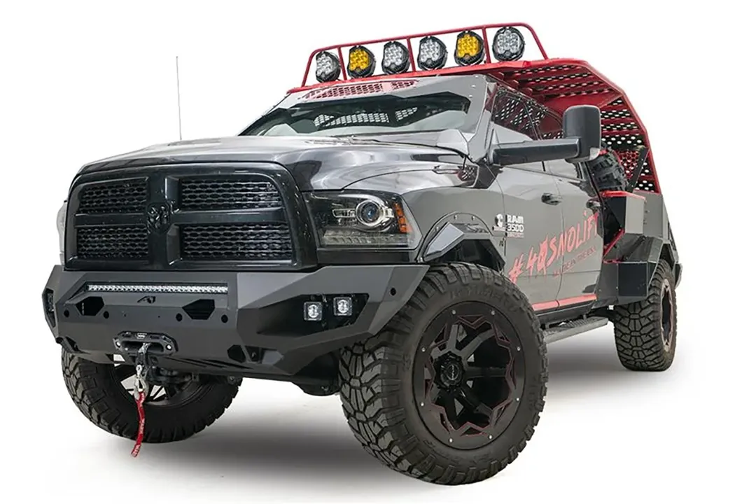 Fab Fours Matrix front bumper on a gray and black Ram 3500, front passenger-side three-quarter view, showing the LED light bar, cube light pods, and center winch