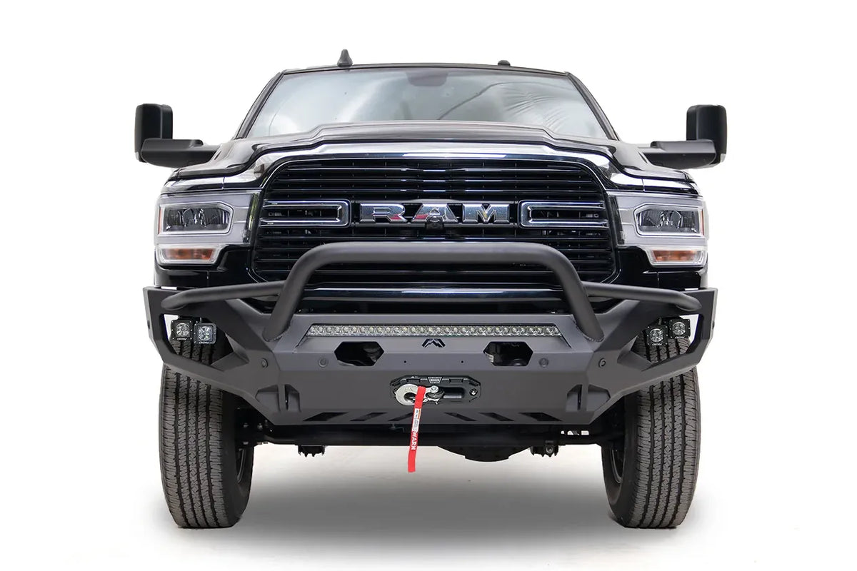 Fab Fours Matrix front bumper with pre-runner guard on a black Ram 2500, straight-on front view, showing the pre-runner bar, LED light bar, and winch fairlead