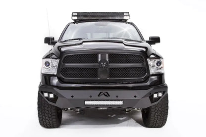 Fab Fours Vengeance front bumper on a black Ram 1500, straight-on front view, showing the center Fab Fours logo, LED light bar, and cube light pods