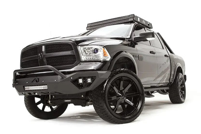 Fab Fours Vengeance front bumper with pre-runner guard on a dark gray Ram 1500, front driver-side three-quarter view, showing the pre-runner hoop, integrated LED cube lights and lower light bar