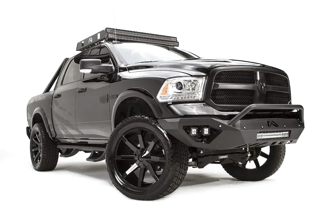 Fab Fours Vengeance front bumper with pre-runner guard on a dark gray Ram 1500, front passenger-side three-quarter view, showing the pre-runner hoop, cube light pods and angled bumper ends