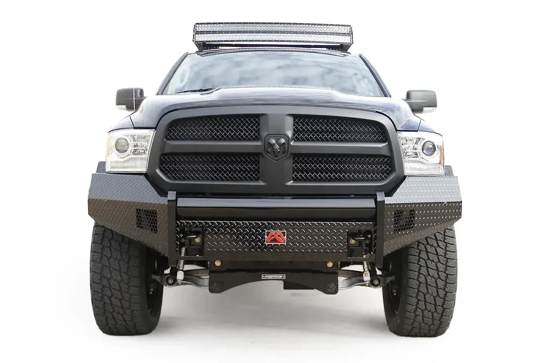 Fab Fours Black Steel front bumper on a black Ram 1500, straight-on front view, showing the diamond-plate face, center tube and red logo badge
