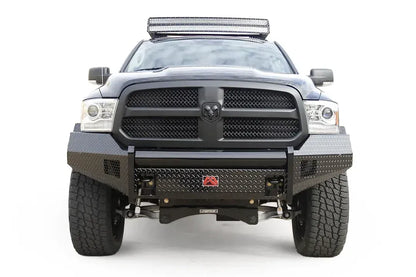 Fab Fours Black Steel front bumper on a black Ram 1500, straight-on front view, showing the diamond-plate face, center tube and red logo badge