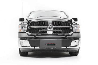 Fab Fours winch mount on a dark gray Ram 1500, straight-on front view, showing the winch plate with fairlead opening, tube hoop and factory chrome bumper ends