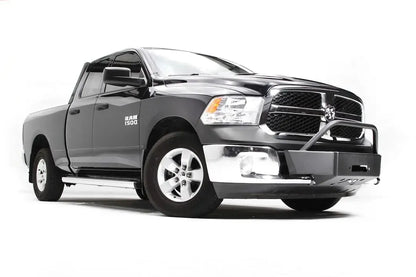 Fab Fours winch mount on a dark gray Ram 1500, front passenger-side three-quarter view, showing the winch plate, tube hoop and factory fog light area