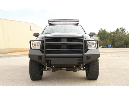 Fab Fours Black Steel Elite front bumper with full guard on a black Ram 1500, straight-on front view outdoors, showing the full grille guard, center tube and mesh end inserts