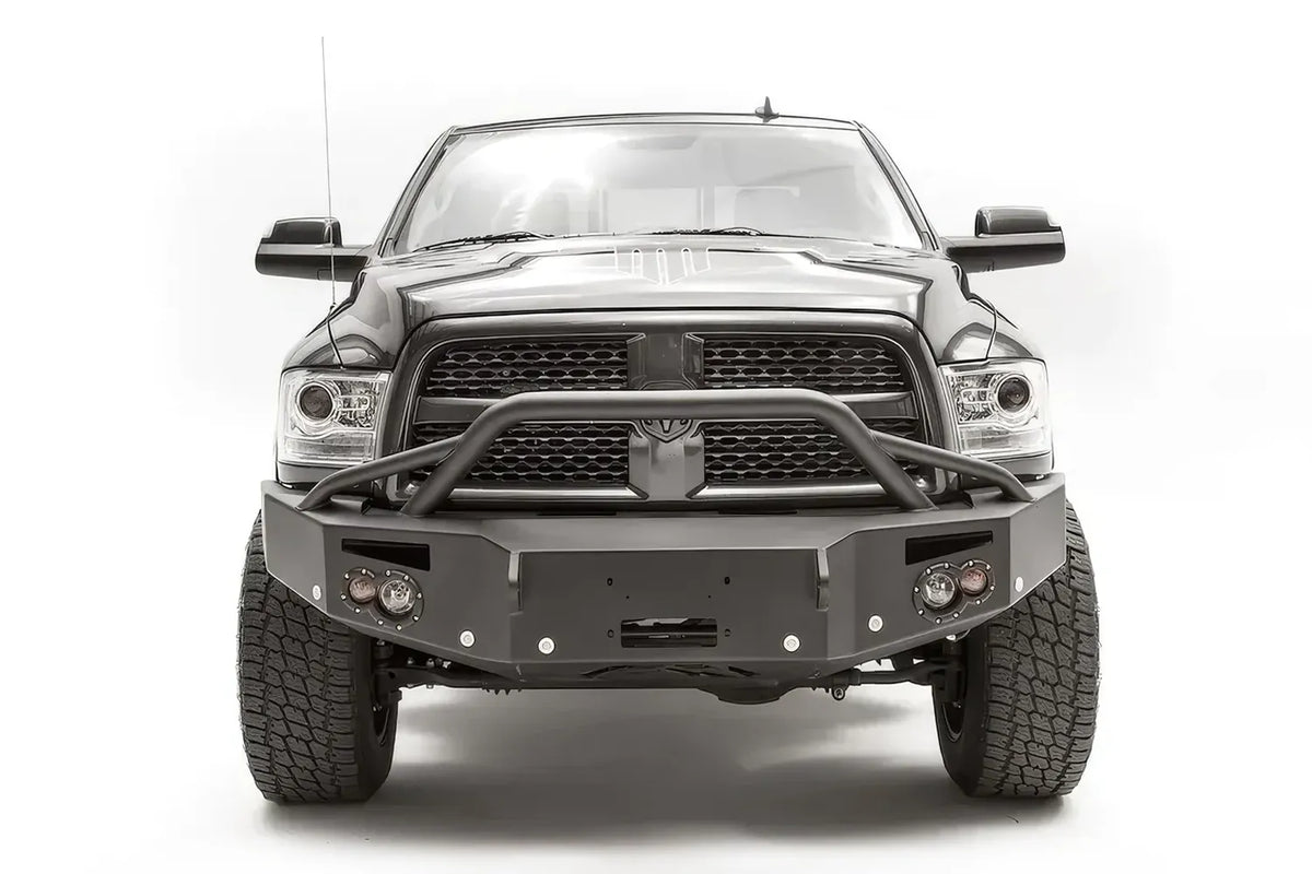 Fab Fours Premium front bumper with pre-runner guard on a black Ram 2500, straight-on front view, showing the pre-runner hoop, winch mount opening and round lights