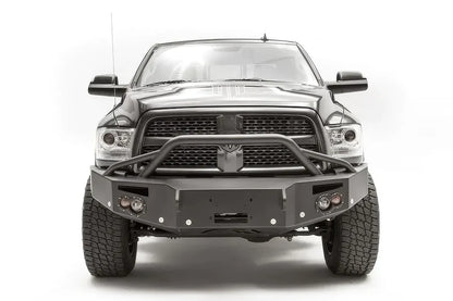 Fab Fours Premium front bumper with pre-runner guard on a black Ram 2500, straight-on front view, showing the pre-runner hoop, winch mount opening and round lights