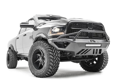Fab Fours Open Fender front bumper on a gray lifted Ram 2500, front passenger-side three-quarter view, showing the pre-runner hoop, integrated light bar and open fender cutaway