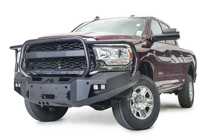 Fab Fours Premium winch bumper with full guard on a dark red Ram 2500, front driver-side three-quarter view, showing the full grille guard hoop, cube lights and winch mount