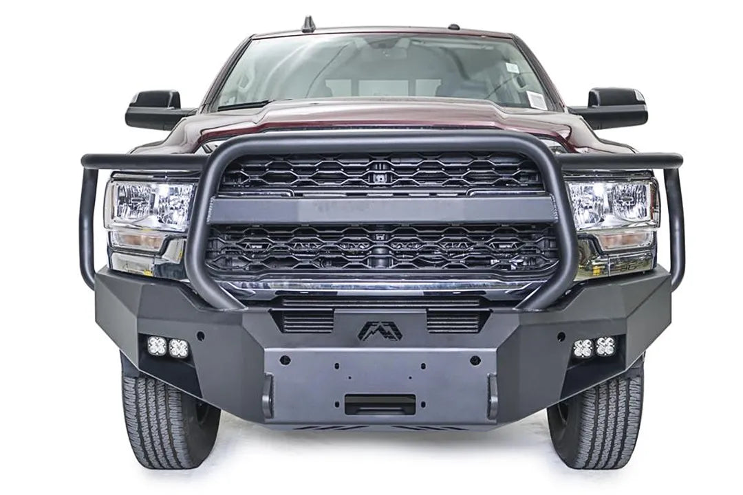 Fab Fours Premium winch bumper with full guard on a dark red Ram 2500, straight-on front view, showing the full grille guard, winch fairlead opening and cube lights