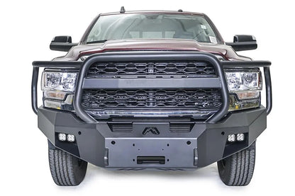 Fab Fours Premium winch bumper with full guard on a dark red Ram 2500, straight-on front view, showing the full grille guard, winch fairlead opening and cube lights