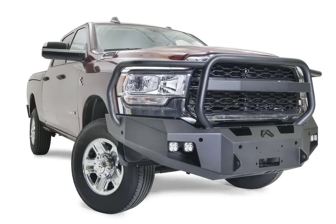 Fab Fours Premium winch bumper with full guard on a dark red Ram 2500, front passenger-side three-quarter view, showing the full grille guard hoop, cube lights and winch mount