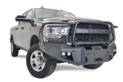 Fab Fours Premium winch bumper with full guard on a dark red Ram 2500, front passenger-side three-quarter view, showing the full grille guard hoop, cube lights and winch mount