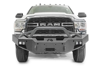 Fab Fours Premium winch bumper with pre-runner guard on a white Ram 2500, straight-on front view, showing the pre-runner hoop, winch fairlead opening and cube lights