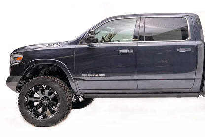 Fab Fours Vengeance front bumper on a dark blue lifted Ram 1500, driver-side profile view, showing the bumper's low profile and wheel clearance