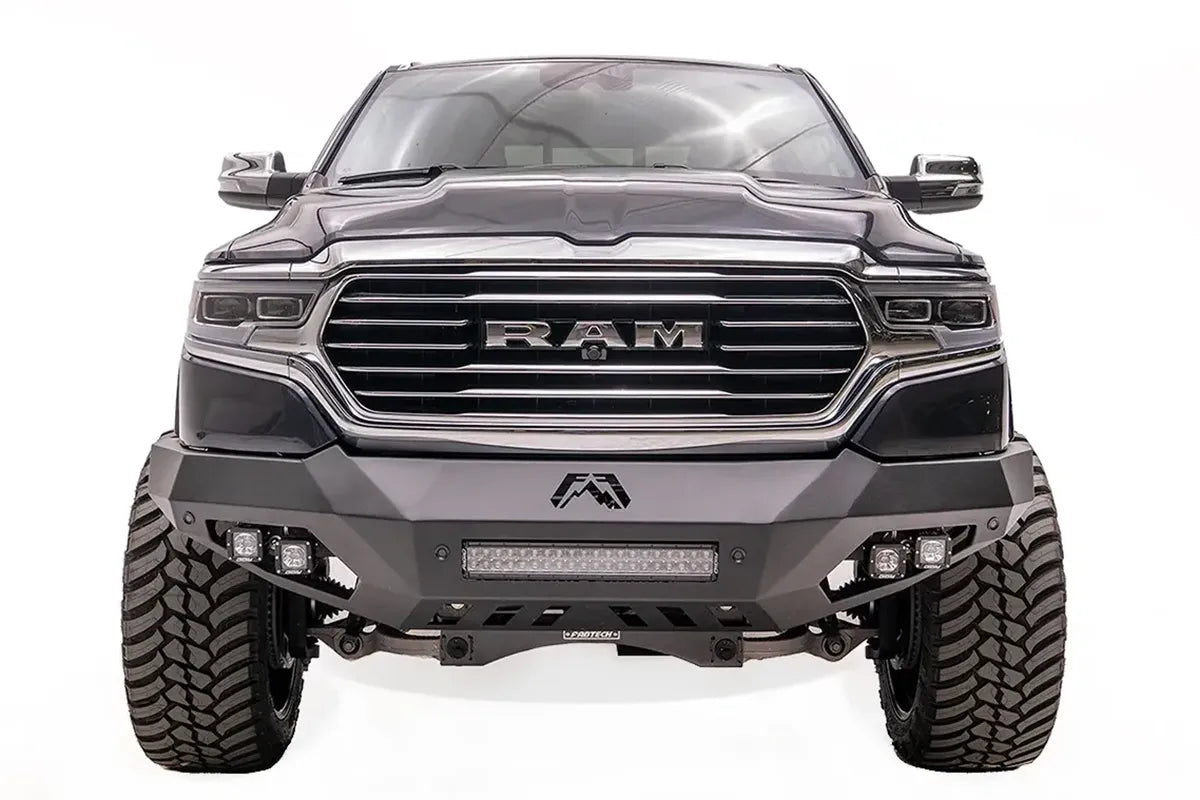 Fab Fours Vengeance front bumper on a dark blue lifted Ram 1500, straight-on front view, showing the integrated light bar, cube light pods and center logo