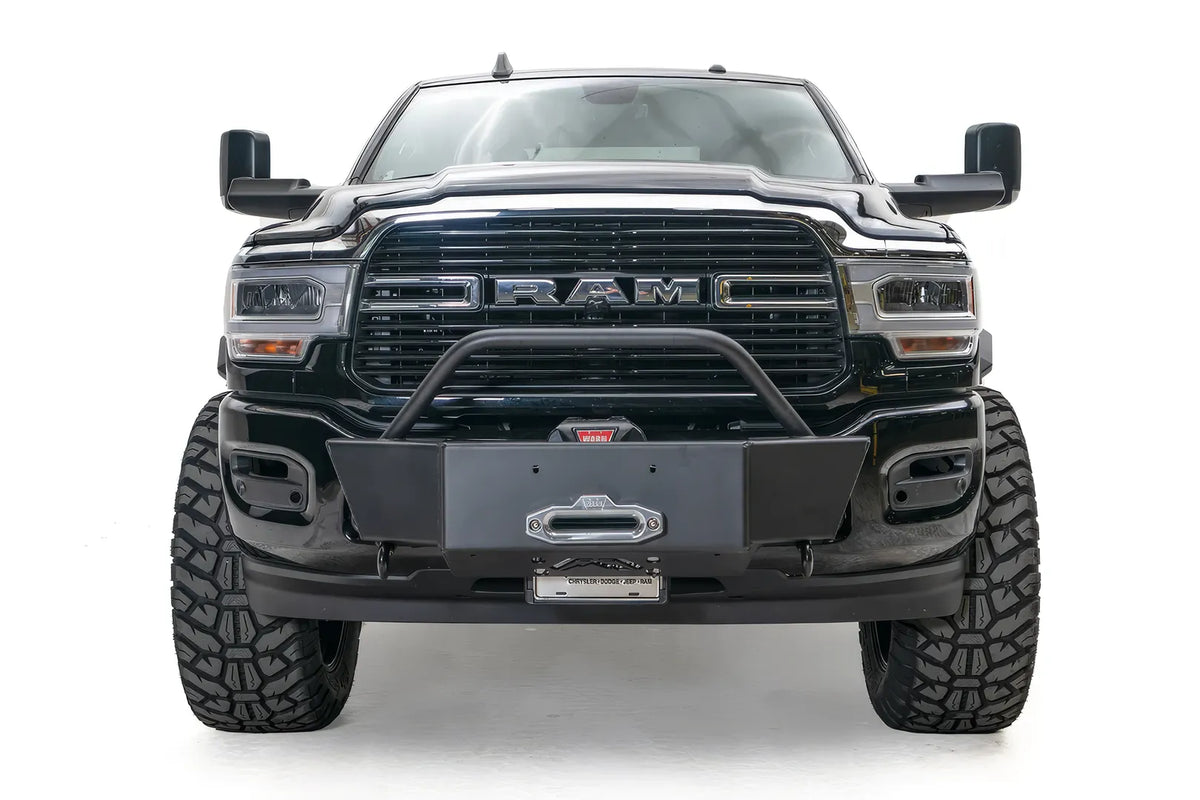 Fab Fours winch mount on a black lifted Ram 2500, straight-on front view, showing the winch plate, fairlead and tube hoop