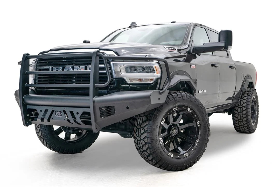 Fab Fours Black Steel Elite front bumper with full guard on a black lifted Ram 2500, front driver-side three-quarter view, showing the full grille guard, slotted skid plate and Elite badge