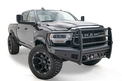 Fab Fours Black Steel Elite front bumper with full guard on a black lifted Ram 2500, front passenger-side three-quarter view, showing the full grille guard, side wraps and skid plate